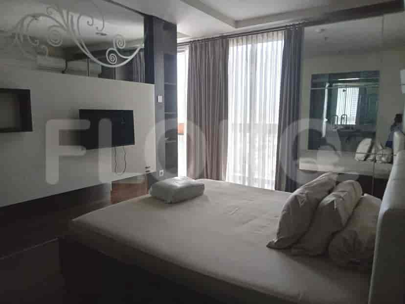 Bedroom with a bed, TV, and mirror.