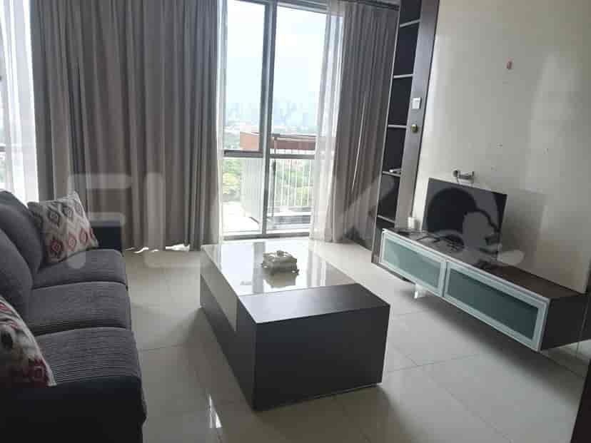 Living room with a sofa, coffee table, large window, and TV.