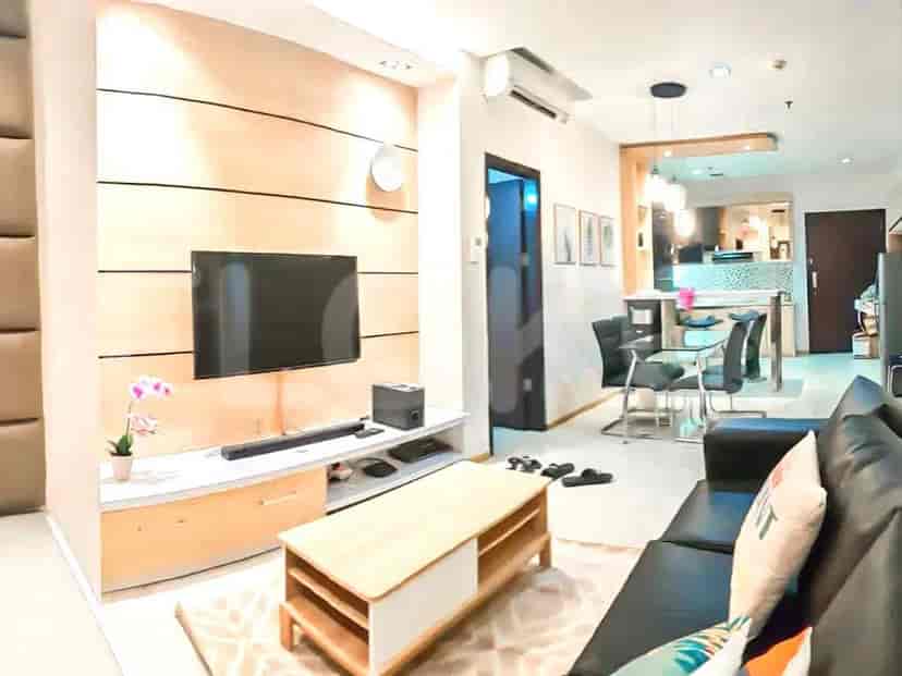 A modern living room with a TV, sofa, and wooden accents.