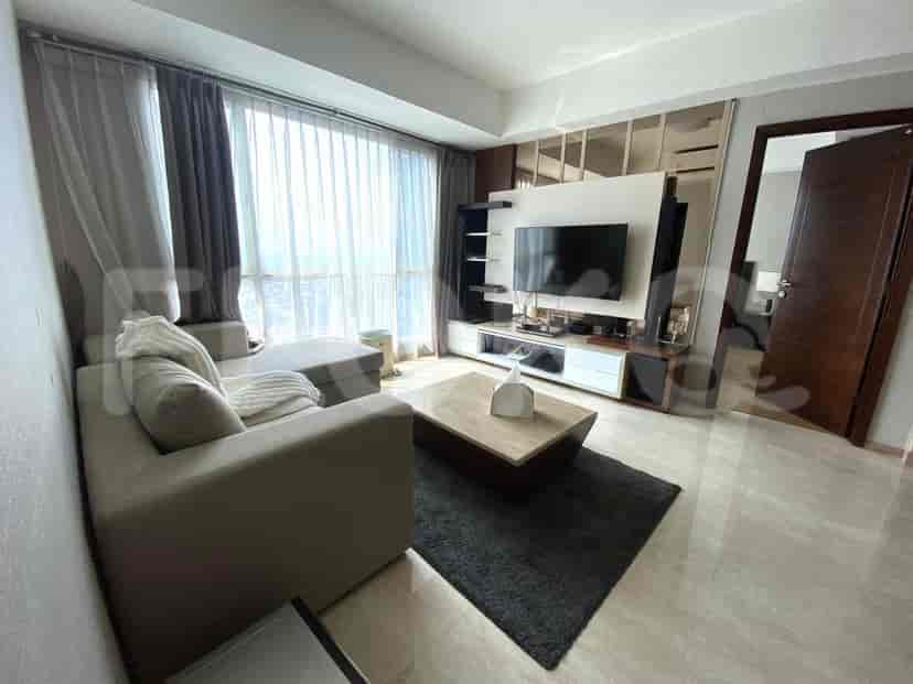 Living room with sofa, TV, and a view of the city.