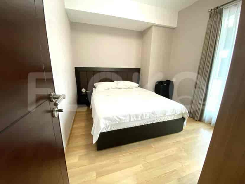 Bedroom with a queen-sized bed and a door to the living area.