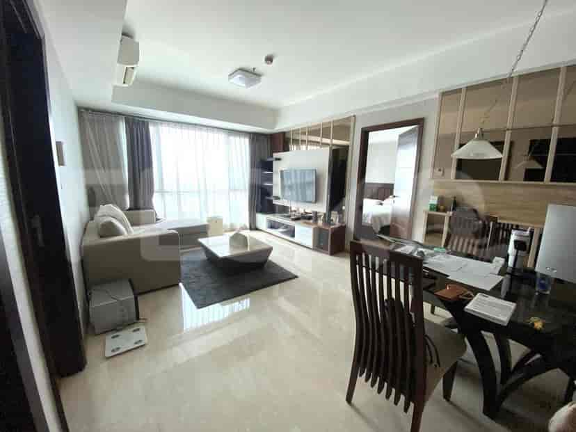 Spacious living room with an L-shaped sofa, TV, and dining area.