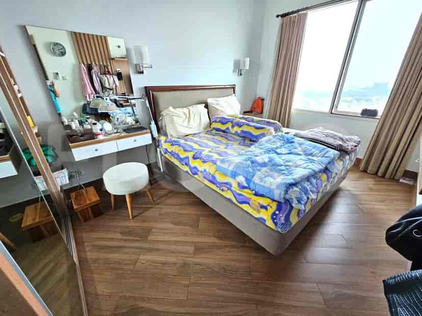 Spacious bedroom with a double bed, vanity, and large window.
