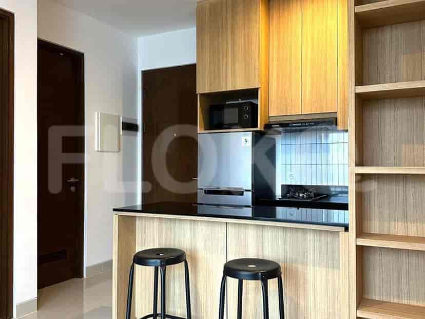 A compact kitchen with a breakfast bar, stainless steel appliances and wooden cabinetry.