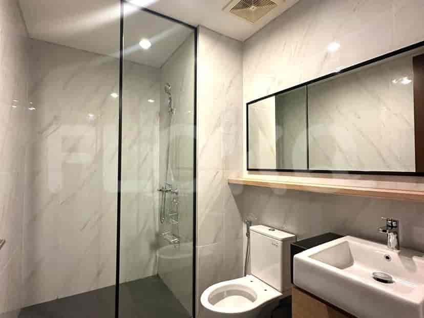 Modern bathroom with a glass shower, white fixtures, and a large mirror.