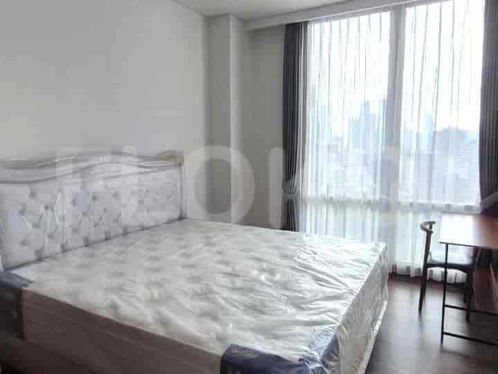 A bedroom with a queen-size bed near a window with curtains.
