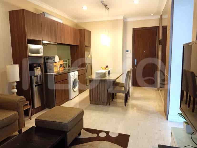 A modern kitchen and dining area with wooden cabinetry, a washing machine, and a dining table.