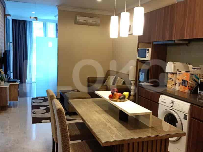 A view of the kitchen and living room area, showing the dining table, sofa, and kitchen.