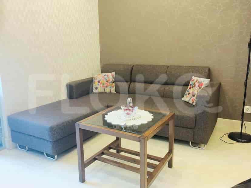 A living room with a grey L-shaped sofa, coffee table, and decorative pillows.