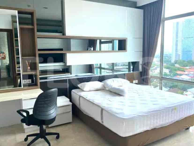 Bedroom with a bed, built-in storage, and a large window.