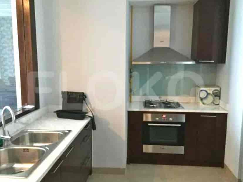 A modern kitchen featuring built-in appliances and a marble countertop.