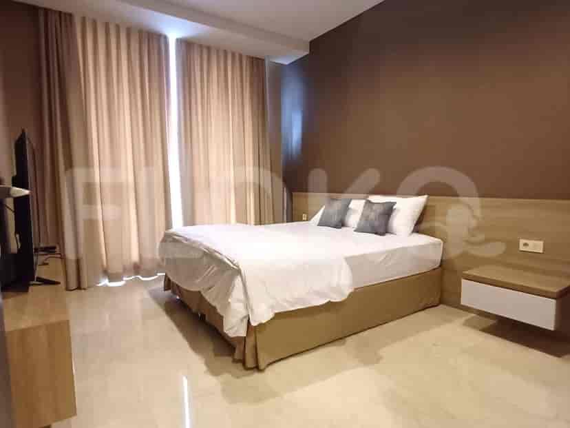 Kamar tidur elegan dengan tempat tidur ukuran queen, headboard kayu, dan meja samping tempat tidur.