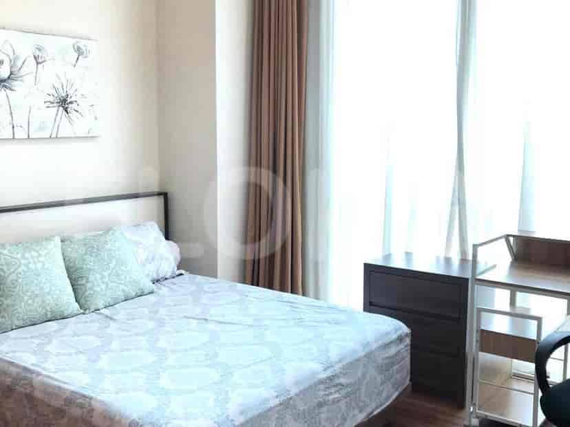 Kamar tidur dengan tempat tidur, meja samping, dan meja kecil.