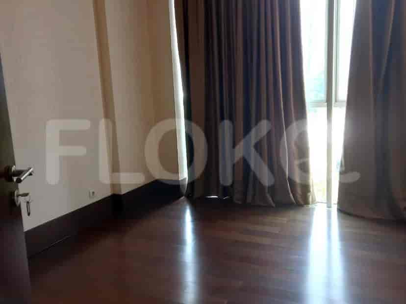 A room with wooden flooring, brown curtains and a door.