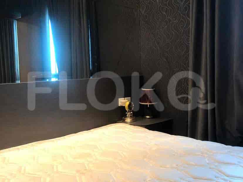 A well-decorated bedroom with a bed, nightstand, and wall decor.