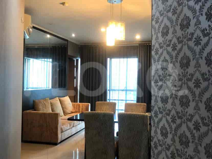 A well-lit living and dining area with a sofa, dining table, and curtains.