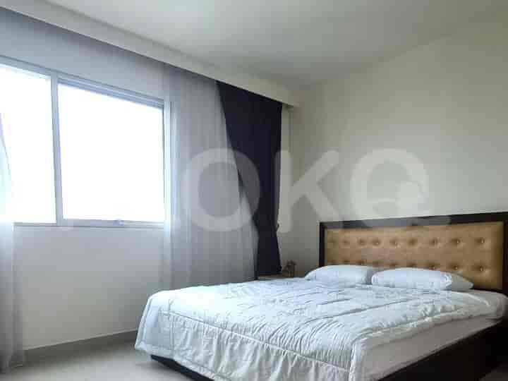 Bedroom with a double bed, window, and curtains.