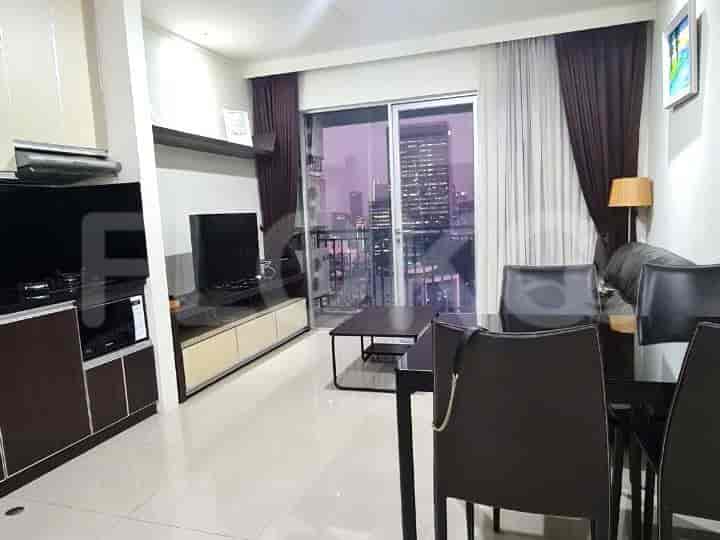 A modern living room with a dining area, featuring a dark wood dining table and city view.