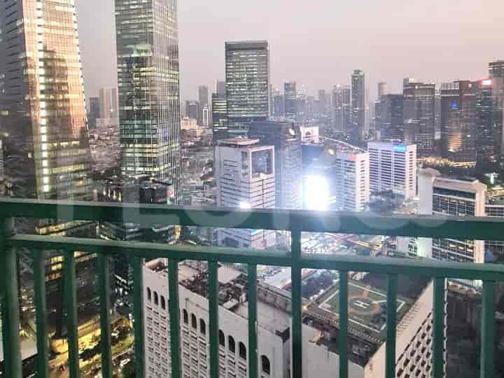 A high-rise balcony offering a panoramic city view at dusk.