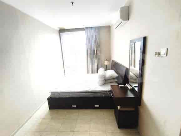 A bedroom with a bed, dressing table, and a large mirror.
