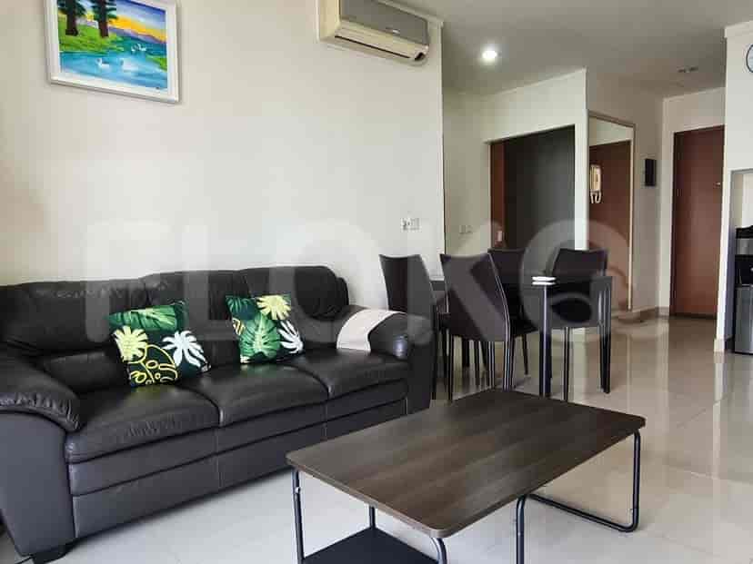 Living room with a sofa, coffee table and kitchen behind.