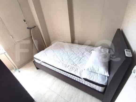 A simple bedroom with a bed and ironing board.