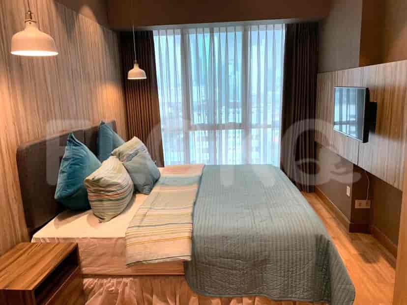 Kamar tidur dengan tempat tidur, TV, dan jendela besar.