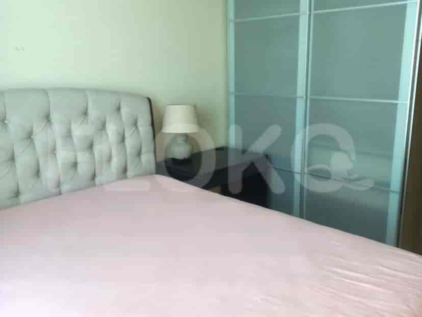 Bedroom with a tufted headboard, side table, and wardrobe with mirrored doors.