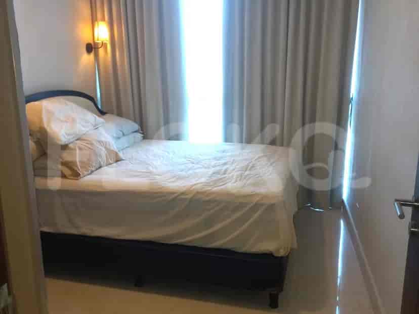 Bedroom with a bed and window with sheer curtains.
