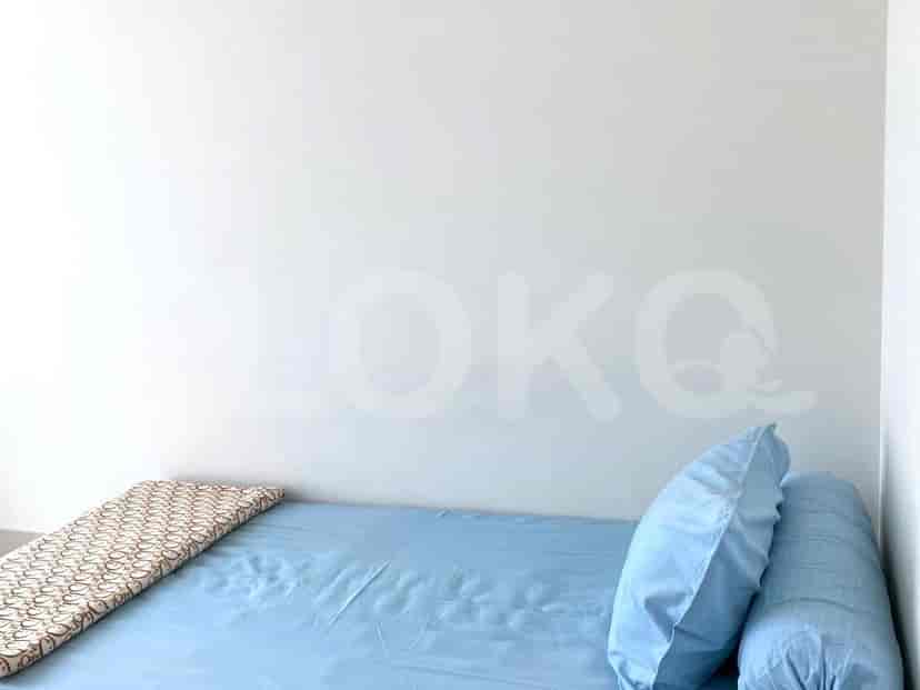 Bedroom with a single bed, blue bedsheets, and pillows.