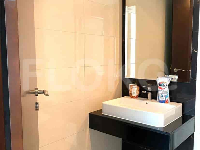Bathroom with a sink, mirror, and beige tiles.