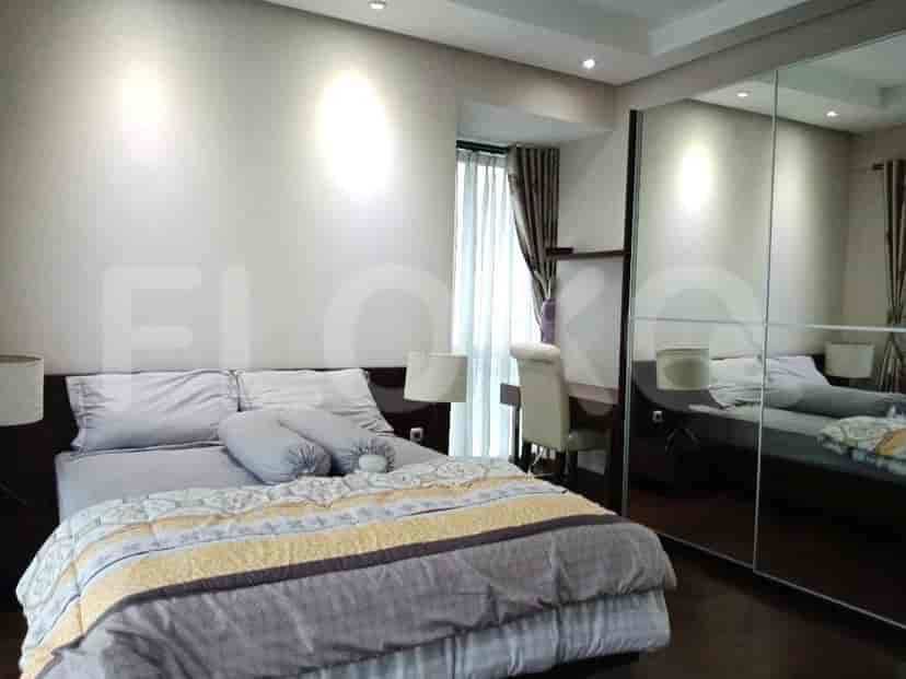 Bedroom with a bed, lamps, and a large mirror.