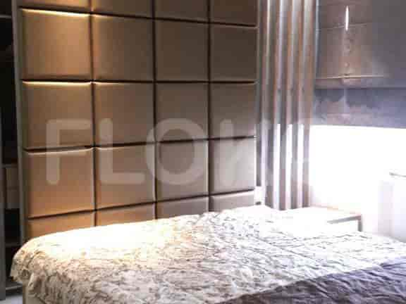 Cozy bedroom featuring a large bed with a patterned bedspread and square headboard.