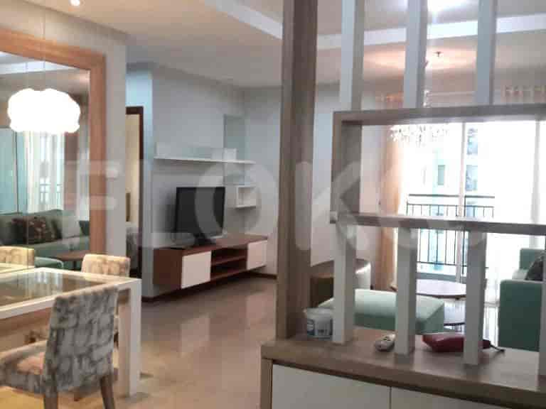Modern living area with a white-and-wood TV stand, turquoise sofa, and dining area.