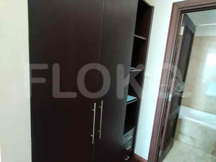 A dark brown wardrobe with doors and shelves.
