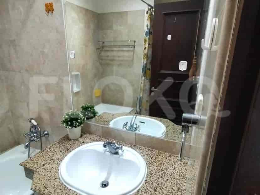 A bathroom with a sink, mirror, and bathtub.