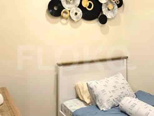 A bedroom with a bed and artwork.