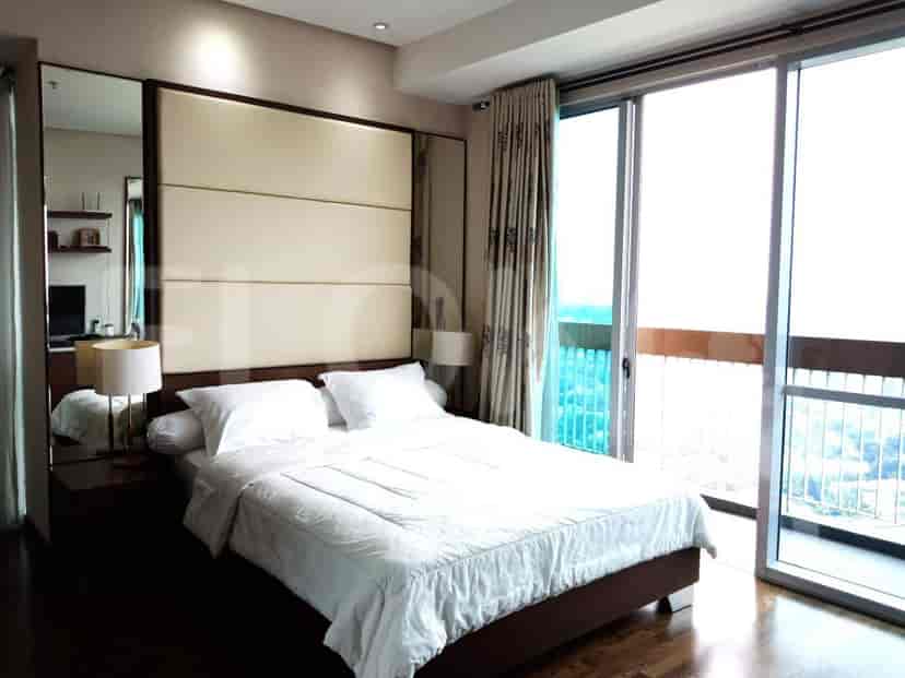 Master bedroom with king bed, lamps, and a balcony view.
