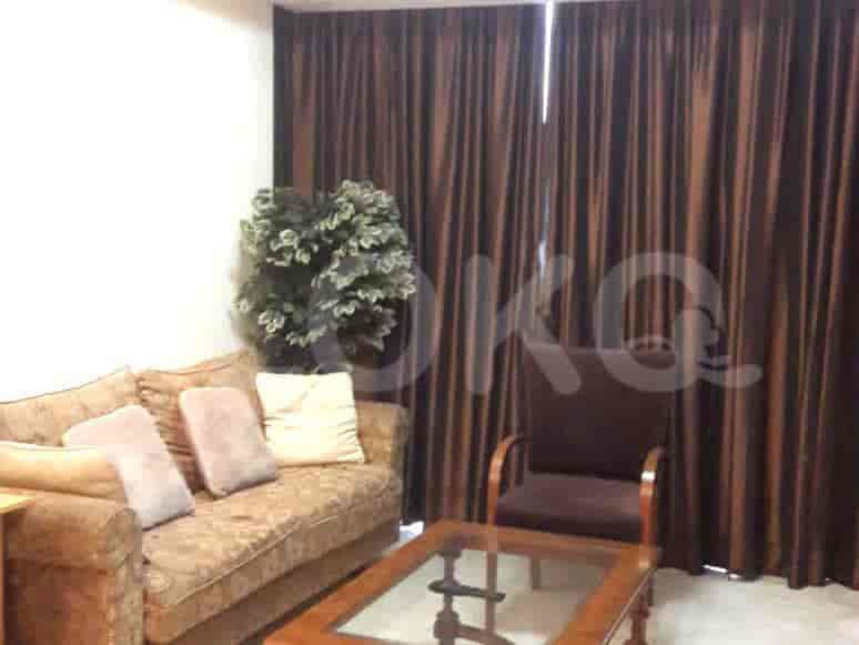Living room featuring a sofa, armchair, coffee table, curtains, and a decorative plant.