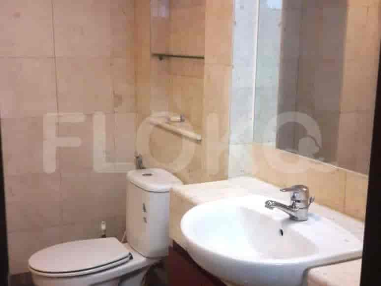 Bathroom featuring a toilet, sink, and mirror.