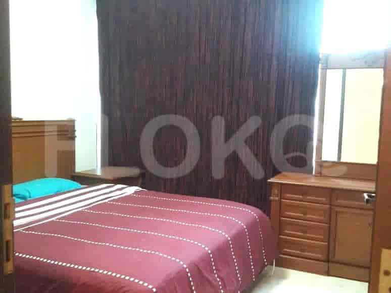 Bedroom featuring a bed, bedside table, dresser, and curtains.