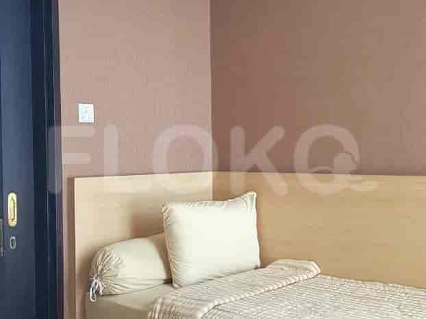 Kamar tidur dengan tempat tidur dan skema warna netral.