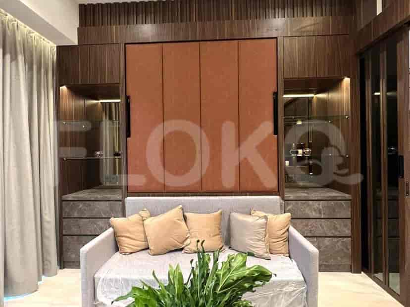 Kamar tidur dengan tempat tidur lipat terintegrasi ke dalam lemari kayu, sofa, dan tanaman.