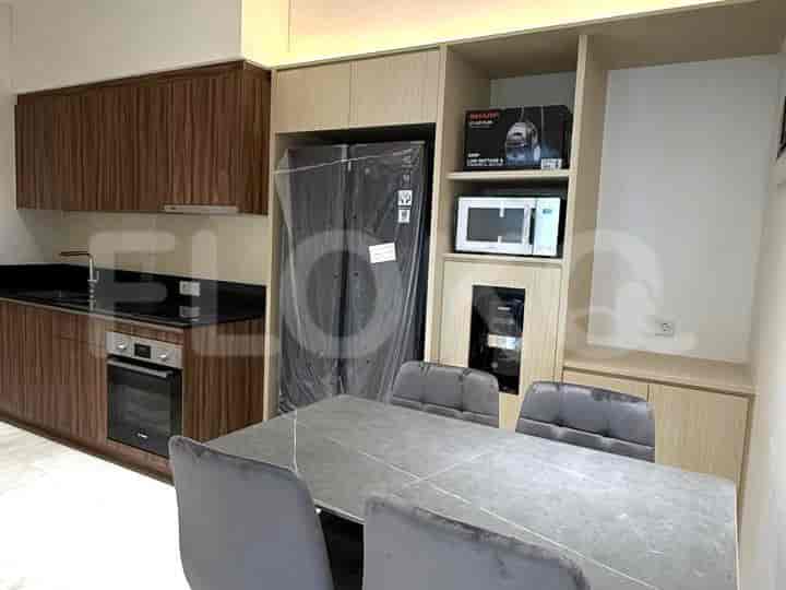 Dapur dan area makan modern dengan peralatan baja tahan karat, lemari kayu gelap, dan meja makan.