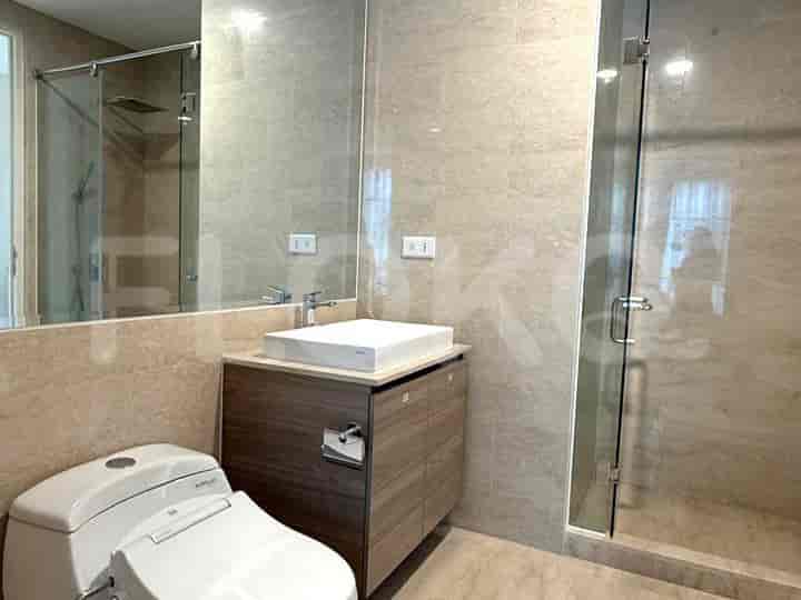 Kamar mandi kontemporer dengan meja rias modern, shower kaca, dan toilet.
