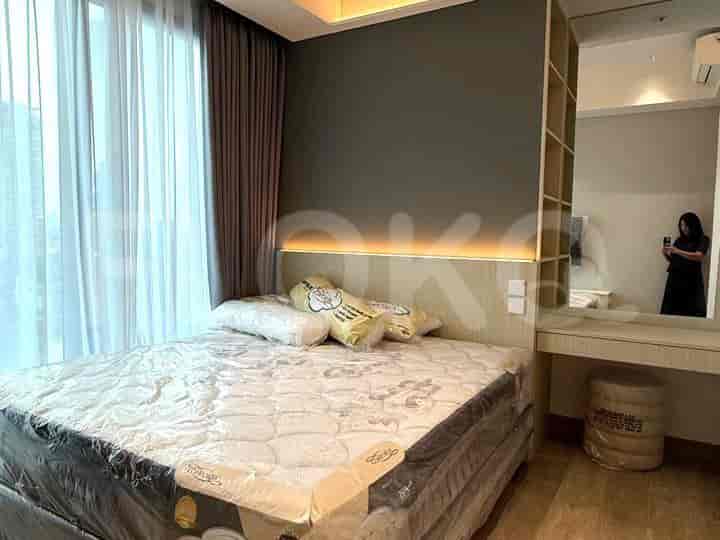 Kamar tidur yang terang dengan tempat tidur dengan linen segar, area rias, dan jendela besar.