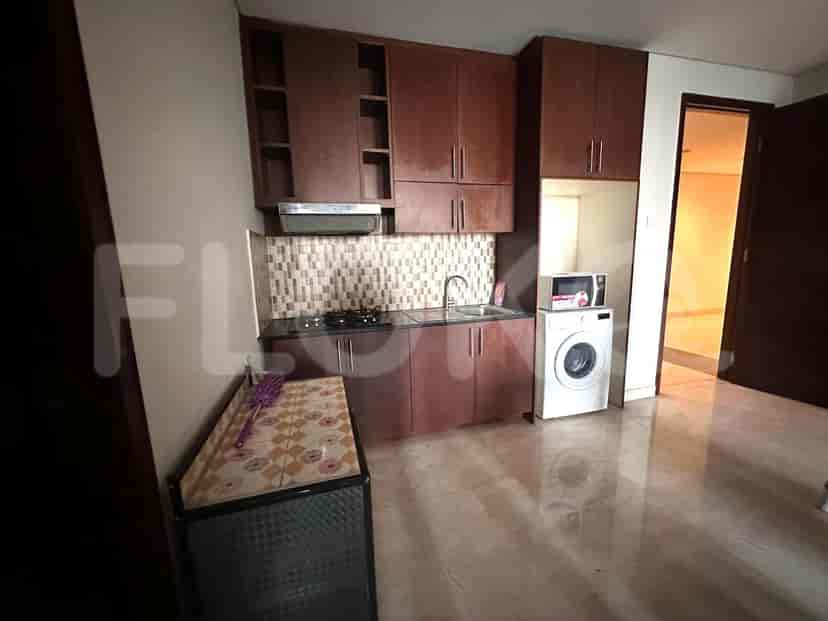 A kitchen area with wooden cabinets, a stove, and a washing machine.