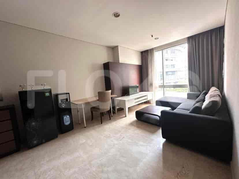 A living room with an L-shaped sofa, water dispenser, and dining area.