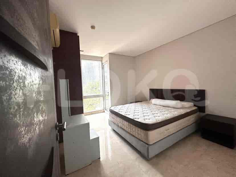 A bedroom with a queen-sized bed, mirror, and air conditioning unit.