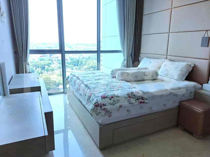 A bright bedroom featuring a bed with floral bedding and a large window.